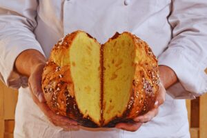 pasticcere che apre in due un panettone con le mani